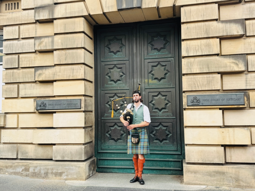 Bagpiper in edinburgh Mna in a kilt playing the bagpipes in the street