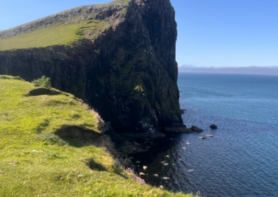 Neist Point cliffs on the Isle of Skye with green grass and blue sea