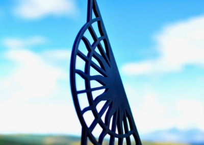 Decorative sundial sculpture silhouetted against blue sky
