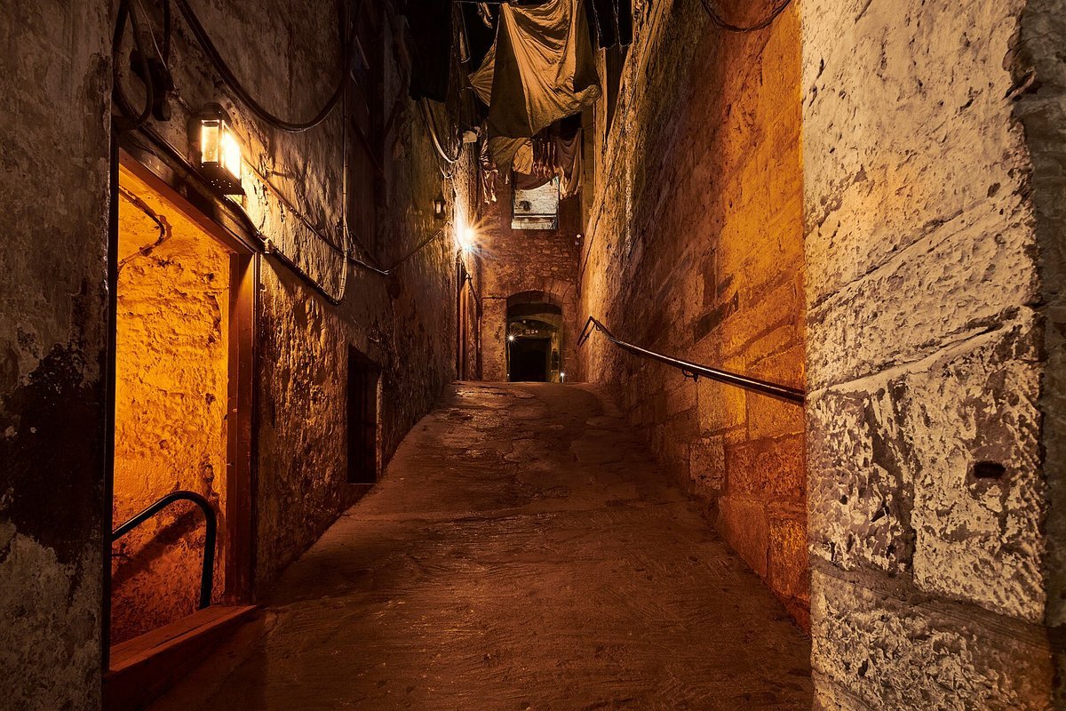 A dim, narrow stone close lit by hanging lanterns in Mary King’s Close, the underground Edinburgh street said to be one of the city’s most haunted sites.